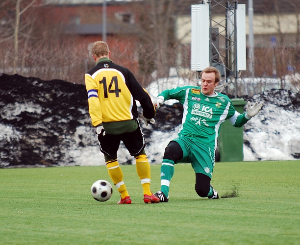 2010_0402_16.JPG - Mikael Wiker suger in bollen framför fötterna på en Immetorpsspelare