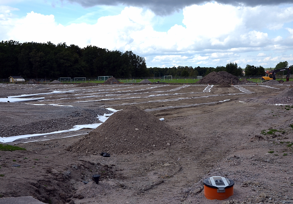 2014_0816_142639AA.JPG - Nu är "diken" för dräneringen gjorda och ett täckningslager med grus börjar läggas ut