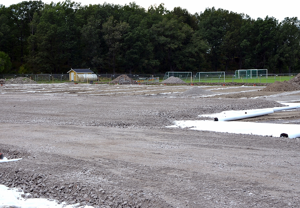 2014_0816_142723AA.JPG - Nu är "diken" för dräneringen gjorda och ett täckningslager med grus börjar läggas ut