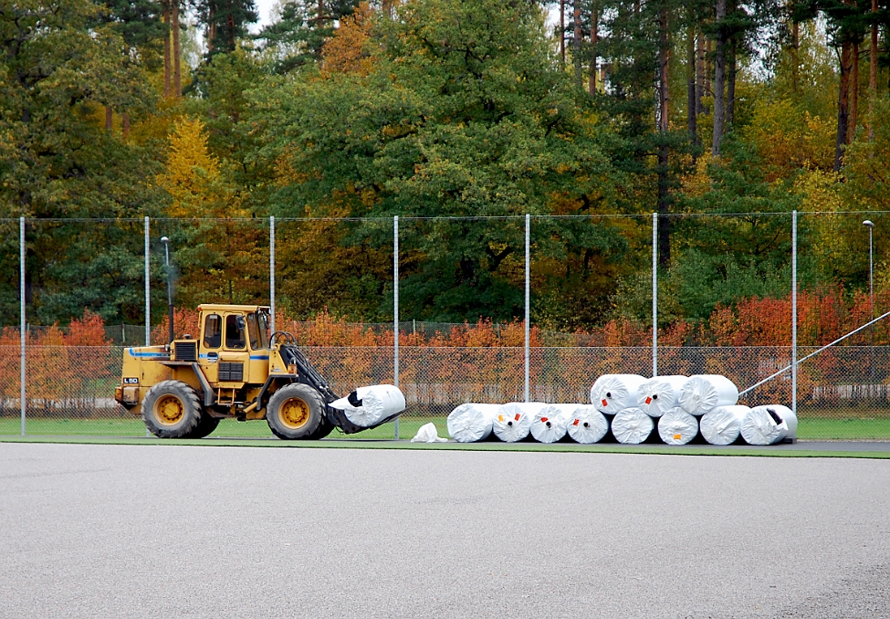 2014_1002_101952AA.JPG - En ny rulle med konstgräs hämtas med baklastaren