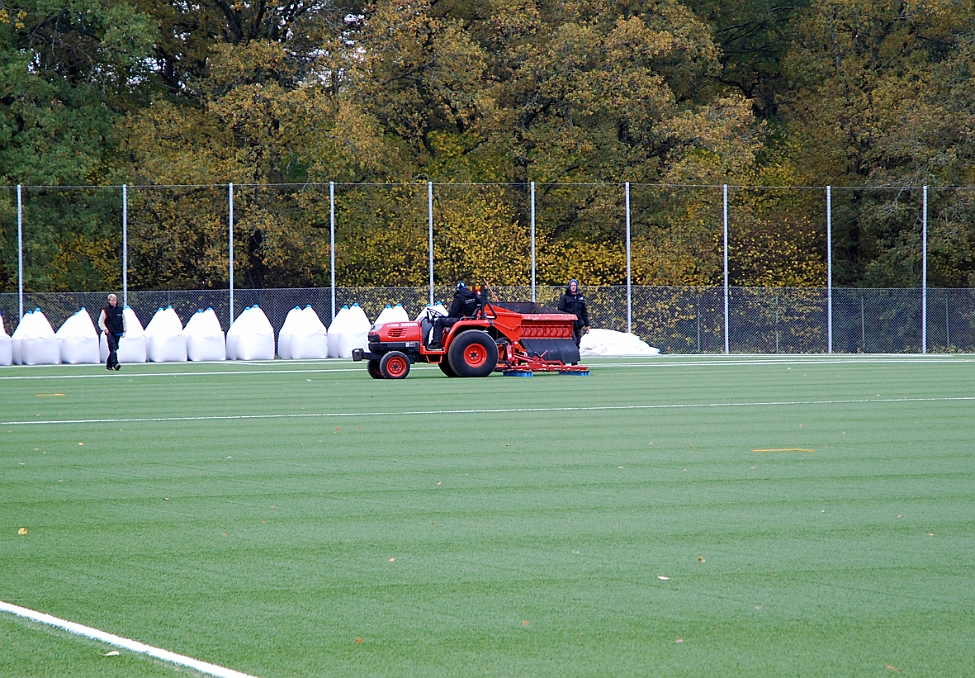 2014_1008_125643AA.JPG - Här borstar man ner gruset till botten av konstgräset